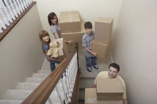 Professional movers carrying furniture through a Maida Vale apartment entrance